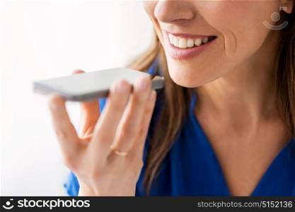 technology, communication and people concept - close up of happy woman using voice command recorder on smartphone. woman using voice recorder on smartphone