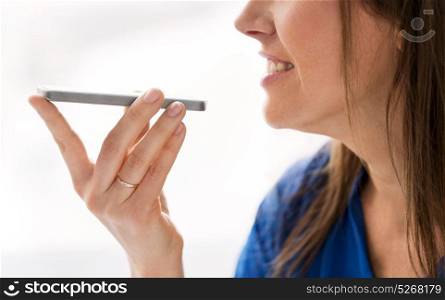 technology, communication and people concept - close up of happy woman using voice command recorder on smartphone. woman using voice recorder on smartphone