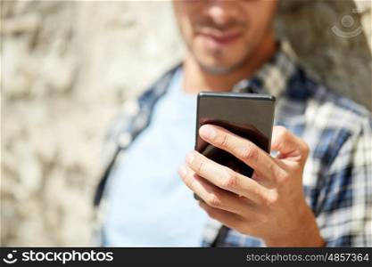 technology, communication and people concept - close up of man with smartphone texting message outdoors