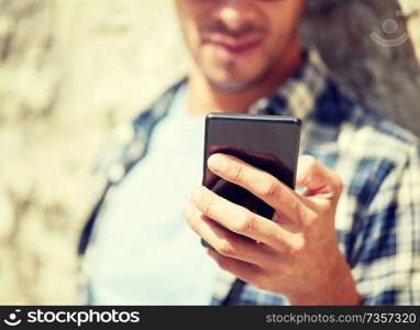 technology, communication and people concept - close up of man with smartphone texting message outdoors. man with smartphone texting message outdoors