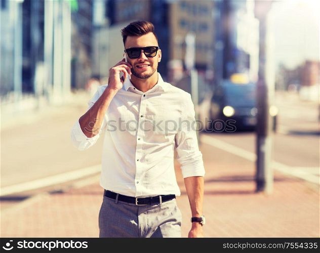technology, communication and people concept - happy man with smartphone calling on city street. happy man with smartphone calling on city street