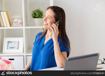 technology, communication and people concept - happy woman calling on smartphone at office or home. woman calling on smartphone at office or home