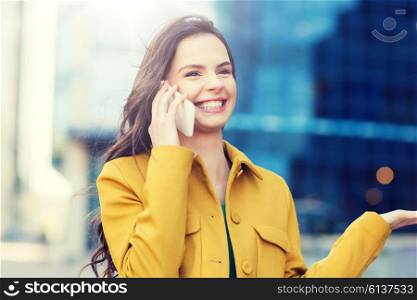 technology, communication and people concept - smiling young woman or girl calling on smartphone on city street. smiling young woman or girl calling on smartphone. smiling young woman or girl calling on smartphone