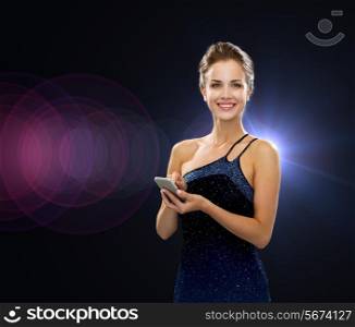 technology, communication, holidays and people concept - smiling woman in evening dress holding smartphone over night lights background