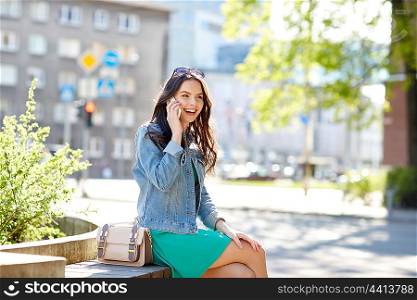 technology, communication, lifestyle and people concept - smiling young woman or teenage girl calling on smartphone on city street