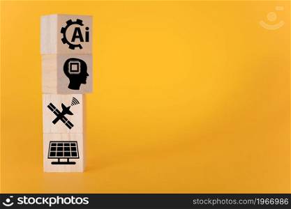 Technology concept with icons on wooden cubes, yellow background. The concept of artificial intelligence.. Technology concept with icons on wooden cubes, yellow background.