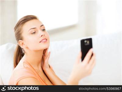 technology concept - woman making self portrait with smartphone