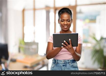 technology, corporate and people concept - happy african american woman using tablet computer over office background. african american woman with tablet pc at office