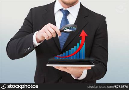 technology, development, analytics , people and business concept - close up of businessman holding magnifying glass over tablet pc computer and growth chart