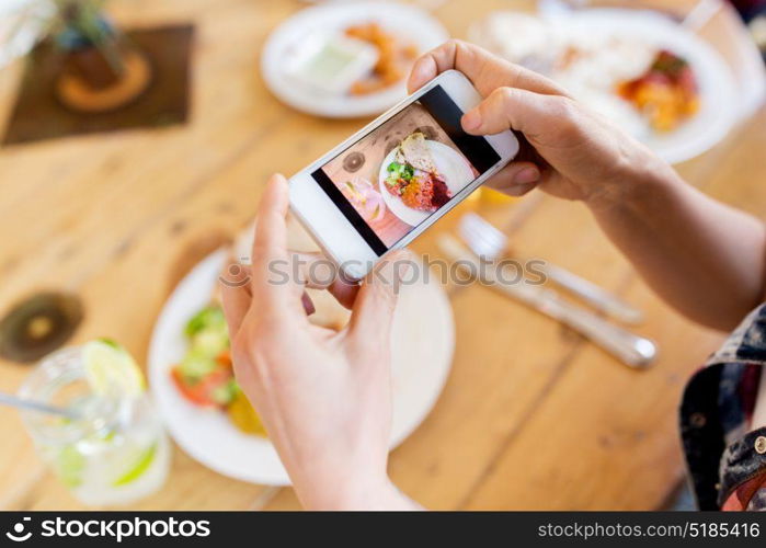 technology, eating and people concept - hands with smartphone photographing food at restaurant. hands with smartphone picturing food at restaurant