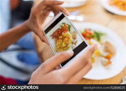 technology, eating and people concept - hands with smartphone photographing food at restaurant. hands with smartphone picturing food at restaurant