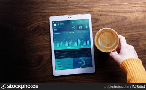 Technology,Finance and Business Marketing in Everyday Life Concept. Woman with Hot Coffee seeing Graphs and Charts show on Digital Tablet. Top View