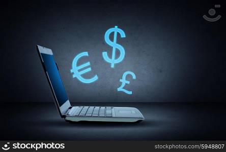 technology, finances and exchange rate concept - open laptop computer with blue lighting currency symbols over dark gray background