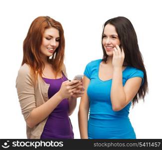 technology, friendship and leirure concept - two smiling teenagers with smartphones texting and calling