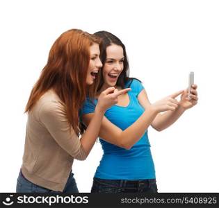 technology, friendship and people concept - two smiling teenagers pointing finger at smartphone