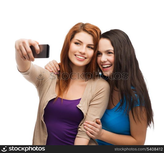 technology, friendship and people concept - two smiling teenagers taking picture with smartphone camera