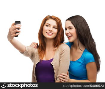 technology, friendship and people concept - two smiling teenagers taking picture with smartphone camera