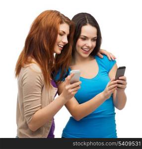 technology, friendship and people concept - two smiling teenagers with smartphones