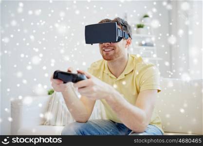 technology, gaming, augmented reality, entertainment and people concept - happy young man with virtual headset or 3d glasses playing video game with controller gamepad at home over snow