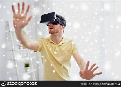 technology, gaming, augmented reality, entertainment and people concept - happy young man with virtual headset or 3d glasses playing video game at home over snow