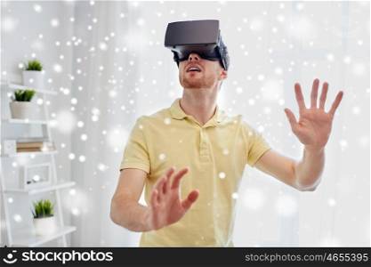 technology, gaming, augmented reality, entertainment and people concept - young man with virtual headset or 3d glasses playing video game over snow