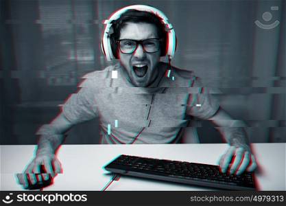 technology, gaming, entertainment and people concept - angry screaming young man in headset with pc computer playing game at home and streaming playthrough or walkthrough video over glitch effect. man in headset playing computer video game at home