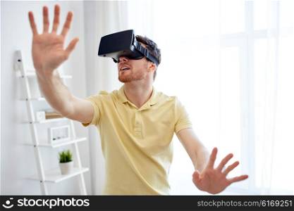 technology, gaming, entertainment and people concept - happy young man with virtual reality headset or 3d glasses playing video game at home