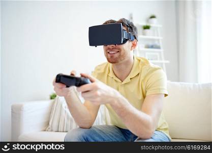 technology, gaming, entertainment and people concept - happy young man with virtual reality headset or 3d glasses playing video game with controller gamepad at home