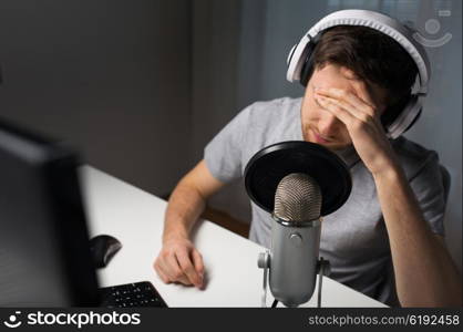 technology, gaming, entertainment, let&amp;#39;s play and people concept - close up of sad young man in headset with pc computer playing game at home and streaming playthrough or walkthrough video