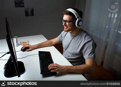 technology, gaming, entertainment, let&amp;#39;s play and people concept - happy young man in headset and glasses with pc computer playing game at home and streaming playthrough or walkthrough video