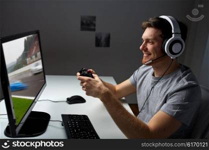 technology, gaming, entertainment, let&amp;#39;s play and people concept - happy young man in headset with controller gamepad playing computer game at home and streaming playthrough or walkthrough video