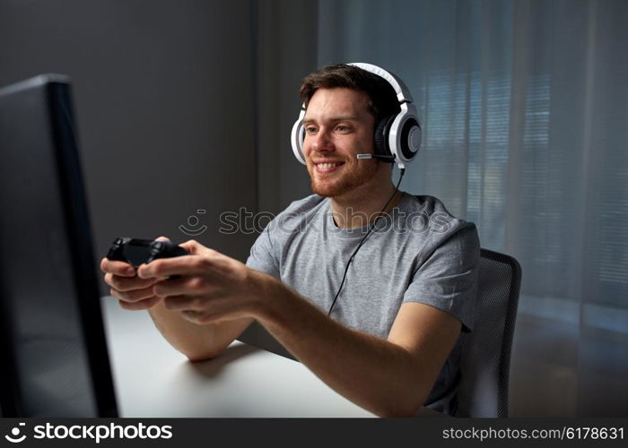 technology, gaming, entertainment, let&amp;#39;s play and people concept - happy young man in headset with controller gamepad playing computer game at home and streaming playthrough or walkthrough video