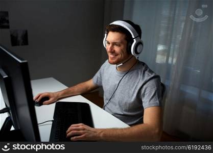technology, gaming, entertainment, let&amp;#39;s play and people concept - happy young man in headset with pc computer playing game at home and streaming playthrough or walkthrough video
