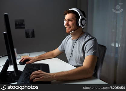 technology, gaming, entertainment, let&amp;#39;s play and people concept - happy young man in headset with pc computer playing game at home and streaming playthrough or walkthrough video
