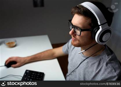 technology, gaming, entertainment, let&amp;#39;s play and people concept - young man in headset and glasses with pc computer playing game at home and streaming playthrough or walkthrough video