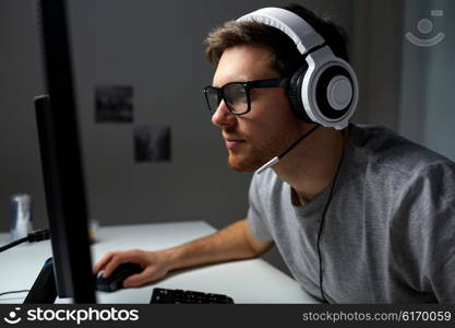 technology, gaming, entertainment, let&amp;#39;s play and people concept - young man in headset and glasses with pc computer playing game at home and streaming playthrough or walkthrough video