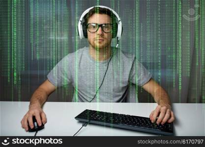 technology, gaming, entertainment, let&amp;#39;s play and people concept - young man in headset and eyeglasses with pc computer playing game at home and streaming playthrough or walkthrough video