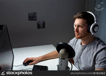 technology, gaming, entertainment, let&amp;#39;s play and people concept - young man in headset with pc computer playing game at home and streaming playthrough or walkthrough video
