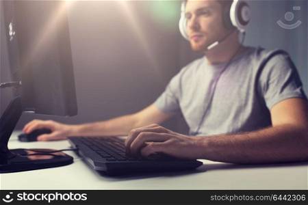 technology, gaming, entertainment, let&rsquo;s play and people concept - close up of young man in headset with pc computer playing game at home and streaming playthrough or walkthrough video. close up of man playing computer video game