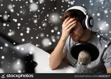 technology, gaming, entertainment, let's play and people concept - close up of sad young man in headset with pc computer streaming playthrough or walkthrough video game and loosing at home over snow