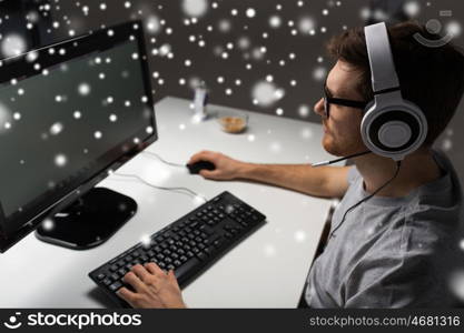 technology, gaming, entertainment, let's play and people concept - close up of man in headset and glasses with pc computer playing game at home and streaming playthrough or walkthrough video over snow