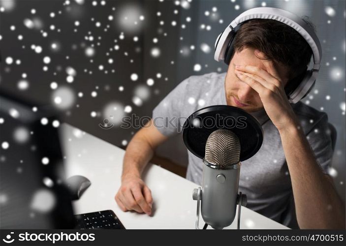 technology, gaming, entertainment, let's play and people concept - close up of sad young man in headset with pc computer playing game at home and streaming playthrough or walkthrough video over snow