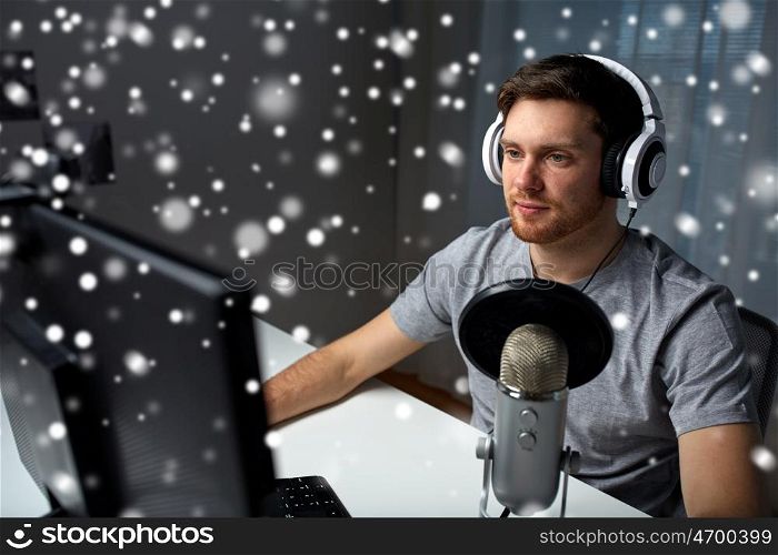 technology, gaming, entertainment, let's play and people concept - happy young man in headset with pc computer playing game at home and streaming playthrough or walkthrough video over snow
