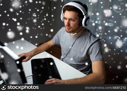 technology, gaming, entertainment, let's play and people concept - young man in headset with pc computer playing game at home and streaming playthrough or walkthrough video over snow