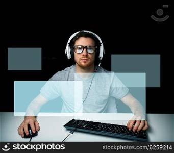 technology, gaming, let&amp;#39;s play and people concept - young man or hacker in headset and eyeglasses with pc computer playing game and streaming playthrough or walkthrough video with virtual screens