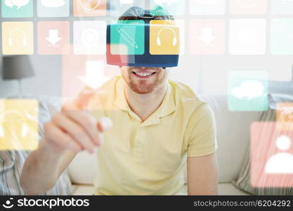 technology, gaming, media, entertainment and people concept - happy young man in virtual reality headset or 3d glasses with computer icons at home