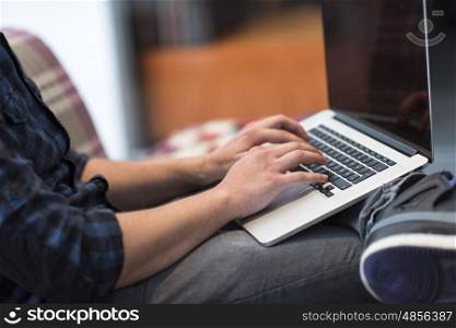 technology, home and lifestyle concept of man working with laptop computer and sitting on sofaa