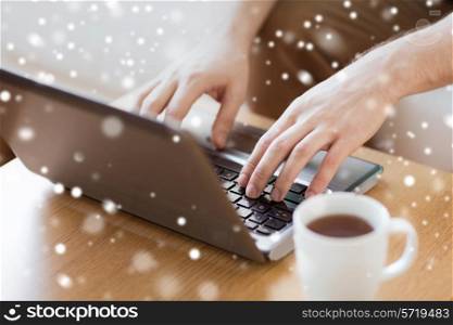 technology, home, drinks and people concept - close up of man with laptop computer and cup of coffee at home
