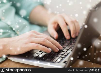 technology, home, people and lifestyle concept - close up of man working with laptop computer and sitting on sofa at home