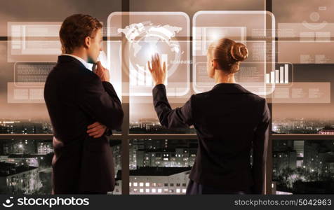 Technology innovations. Rear view of businessman and businesswoman touching icon of digital screen